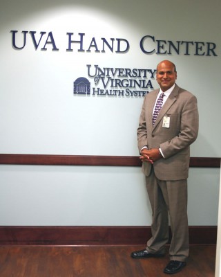 Dr. Chhabra stands at the entrance to the beautiful UVA Hand Center.