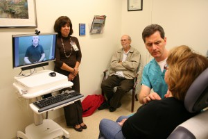 Wanda Biser (right) tries out a new American Sign Language video interpreting system as she talks with dermatologist Mark Russell, MD.