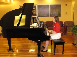 Junior volunteer Elise Mollica plays the piano at UVA Hospital.