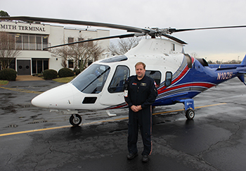 Pegasus flight nurse Shawn Reid in front of the secondary Pegasus helicopter