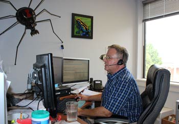 Poison control nurse Andre Berkin at his desk, talking with a patient on the phone