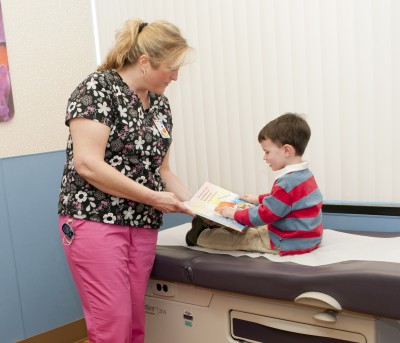 Tanya Smith gives a young patient a book as part of the Augusta Pediatrics Reach Out and Read Program.