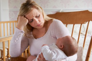 A tired mother finds breastfeeding her baby challenging.