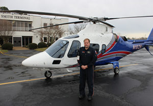 Shawn Reid in front of helicopter