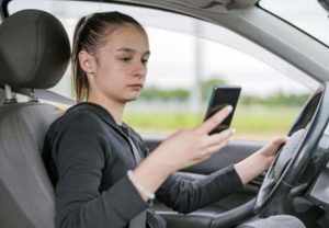 teen is practicing distracted driving