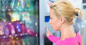 Woman picking snack at vending machine