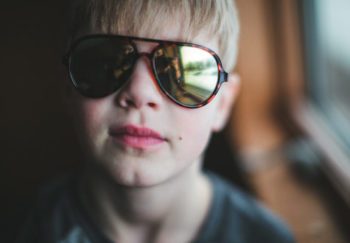 child with sun sensitivity wearing sunglasses