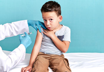 young boy about to get a shot looks suspicious