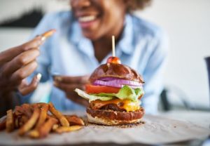 Woman enjoying a cheeseburger and fries