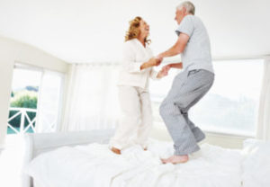 older couple jumping on the bed