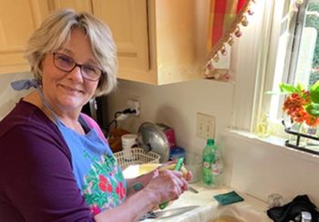 Marcia peeling potatoes over a sink