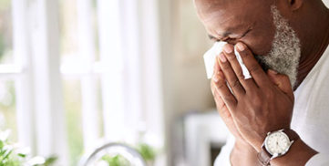 A man with hypertension blows his nose. He's in need of a decongestant that won't raise his blood pressure.