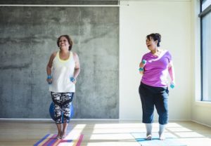 two woman working out together trying not to over-exercise and cause injury