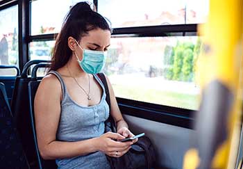female bus passenger wears a face mask to avoid coronavirus infection