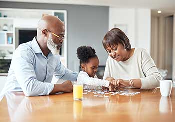 A family working together on a puzzle while they follow their local stay-at-home order.