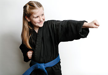 young girl wearing karate uniform, punching