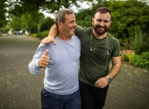 father & son walking outside together, wearing workout clothes