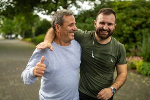 father and son in workout clothes walking together, laughing
