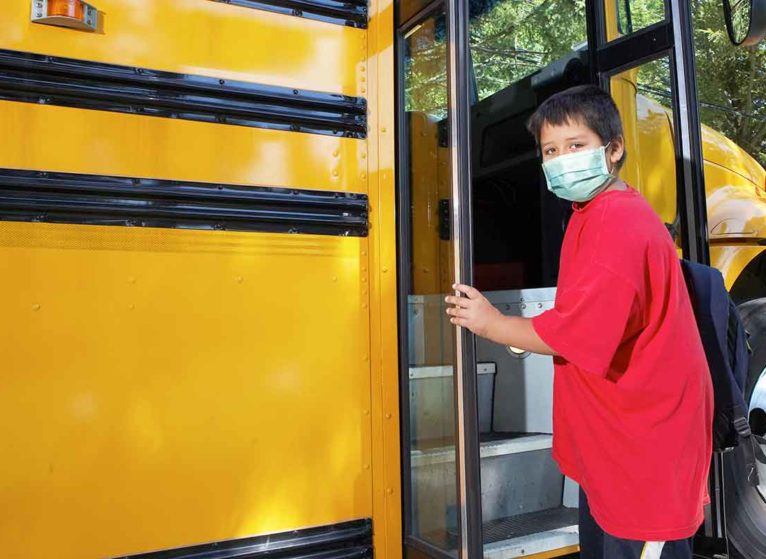 young boy getting onto school bus