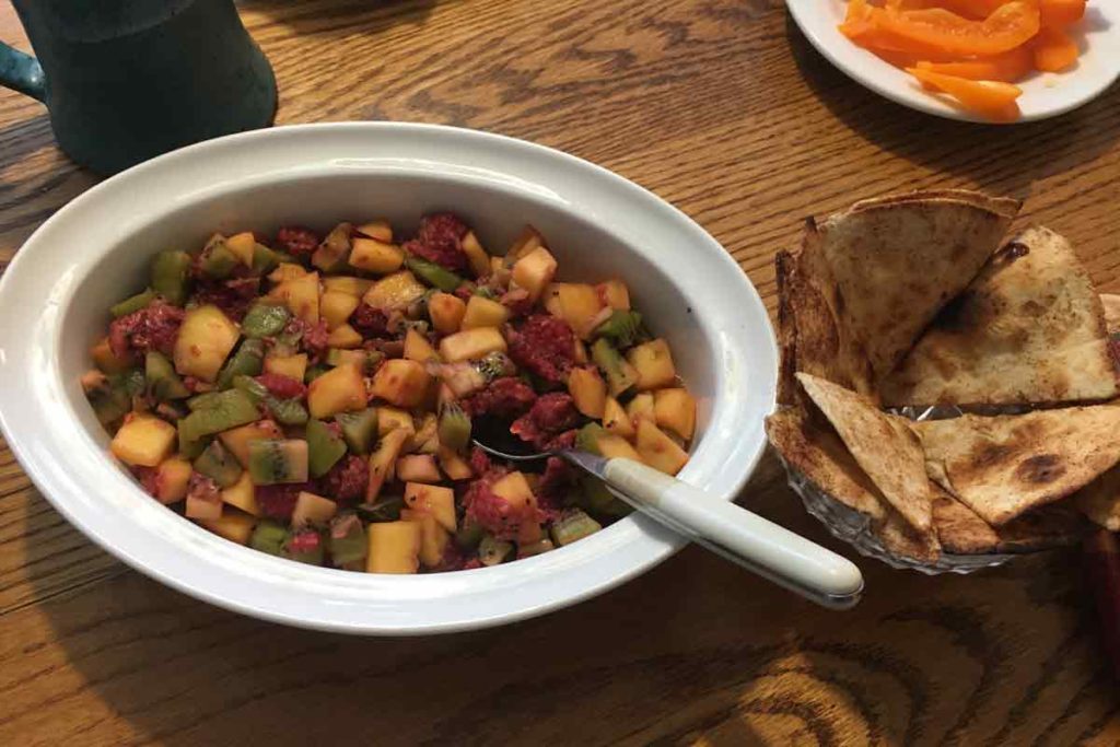 Fruit salsa in a dish with cinnamon chips on the side.
