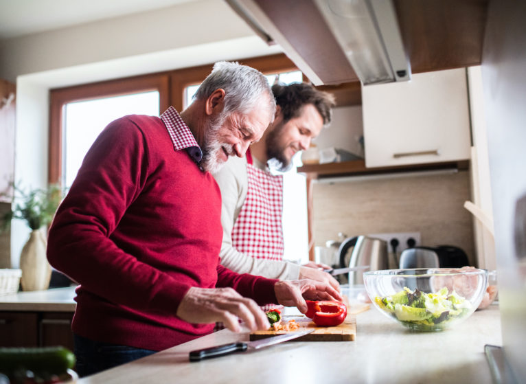 Son and father cooking a healthy meal, heart health tips