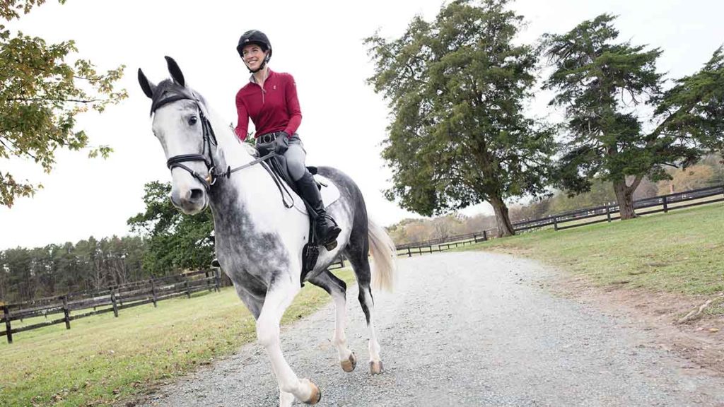 Bajo and her gray mare, Tika, trot down a gravel driveway