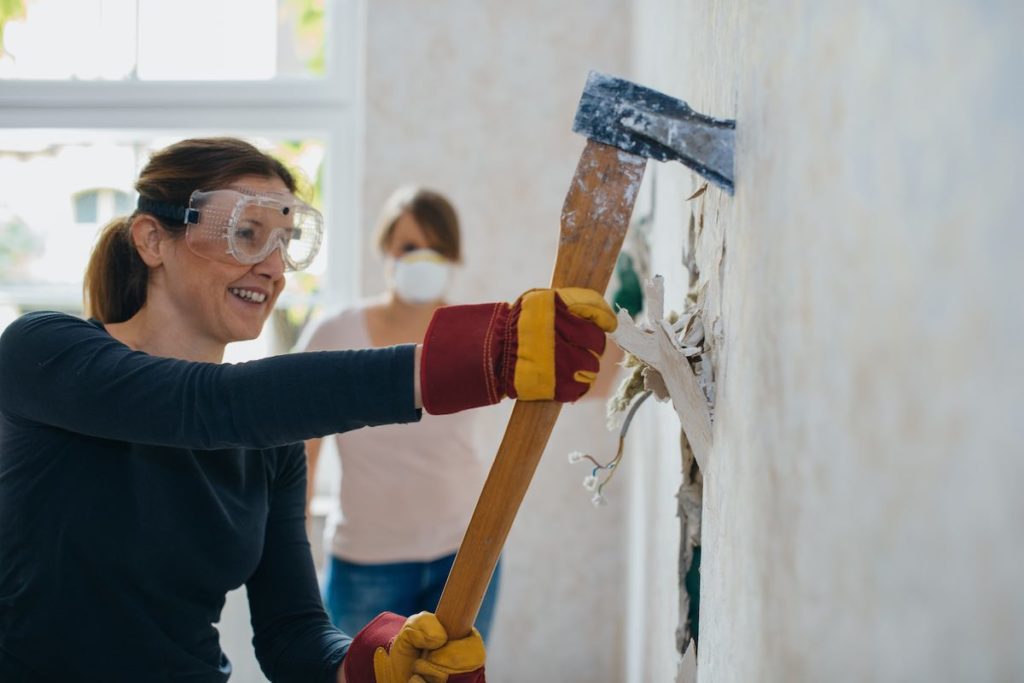 woman taking an ax to a wall