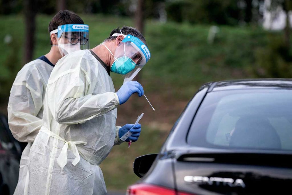 man providing Covid test at drive-thru event