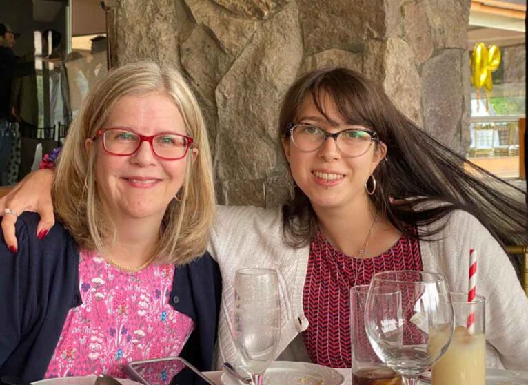 Jennifer Payne, MD, sitting at a table with her daughter Amanda