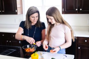 Childhood cancer survivor Anna and mom Krissy making dinner
