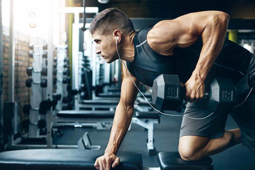 man working out in gym to gain muscle mass
