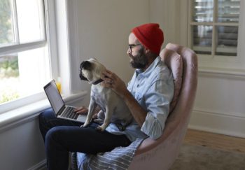 man working from home with dog on lap
