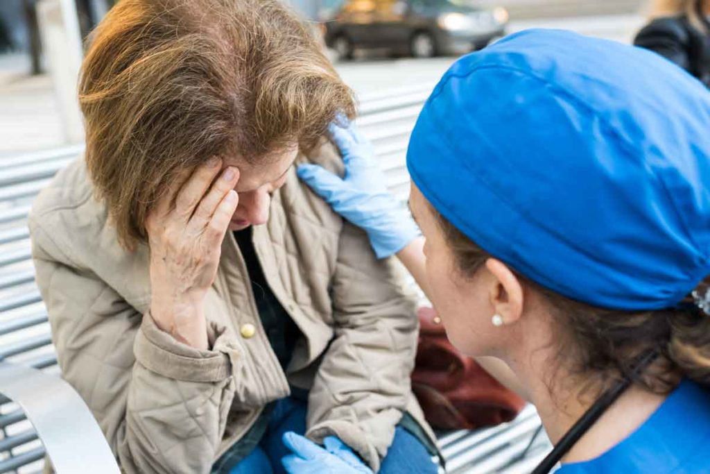 An older woman getting help from a female healthcare provider