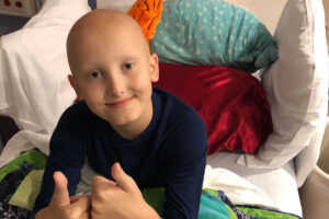 Benny gives a thumb's up. A year after his child's cancer diagnosis, this dad reflects.