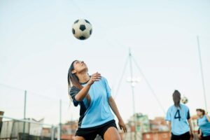 woman gets ready to head butt soccer ball