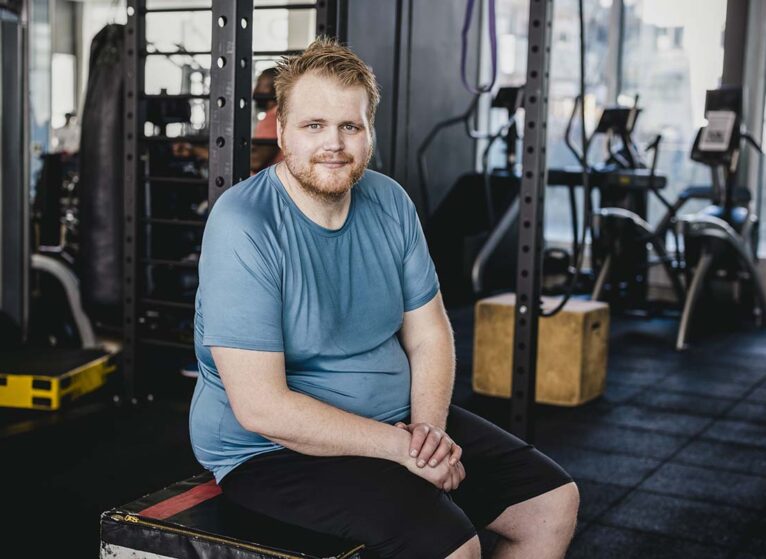 overweight man at the gym, where he might experience fatphobia