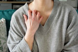 woman scratching her neck because of an eczema flare up