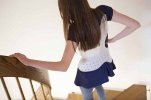 Girl in scoliosis brace walks down the stairs