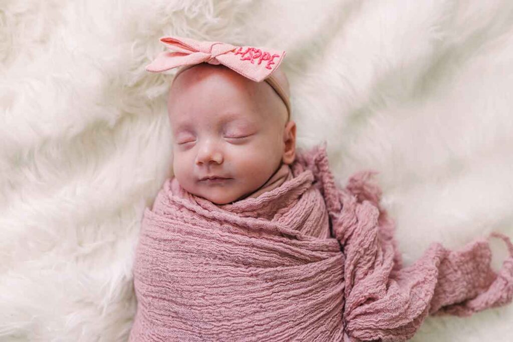 A happy pink-swaddled newborn, Emery survived her mother's cancer treatments in utero.