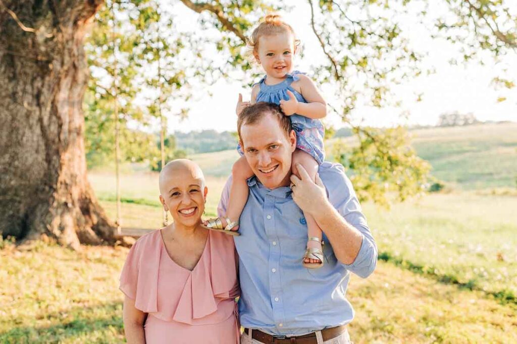 A pregnant Dana, bald from chemo, with her daughter and husband.