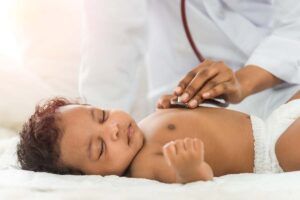Doctor uses stethoscope to listen to baby's heart
