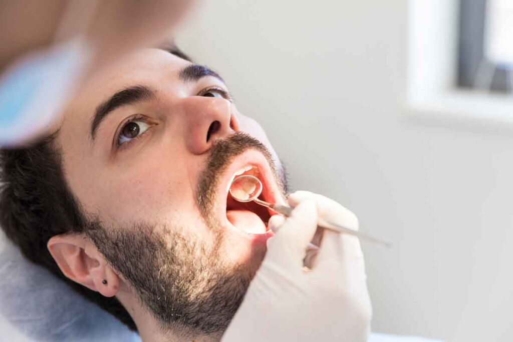 man getting an oral cancer screening at dentist