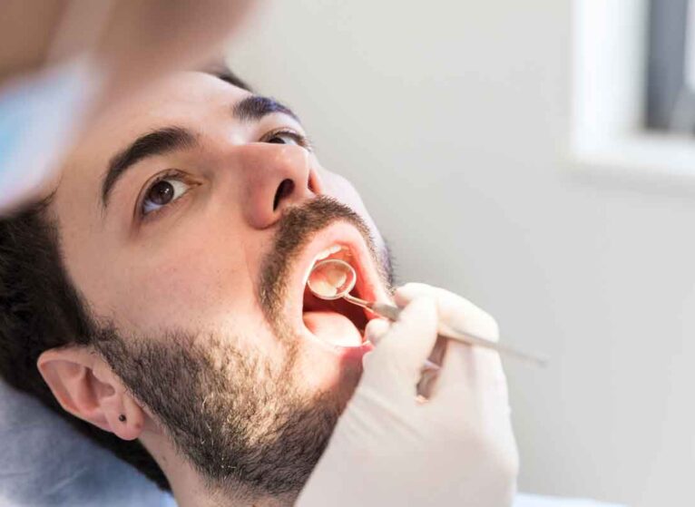 man getting an oral cancer screening at dentist