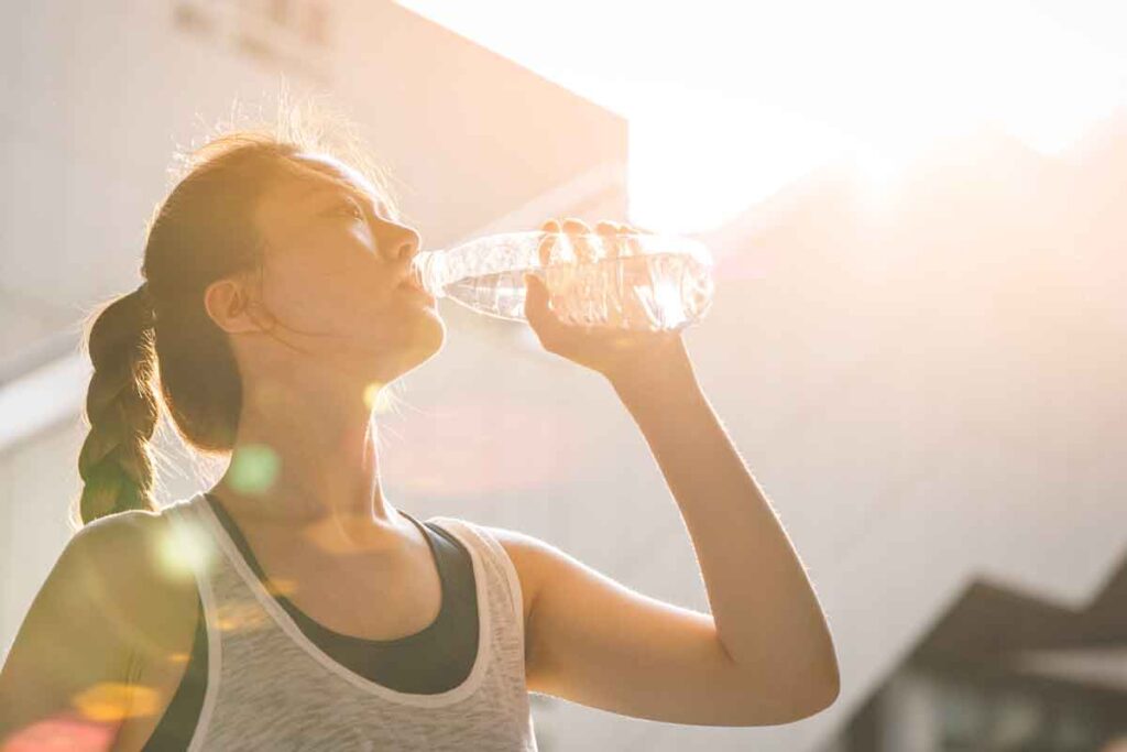 woman drinking water in hot weather