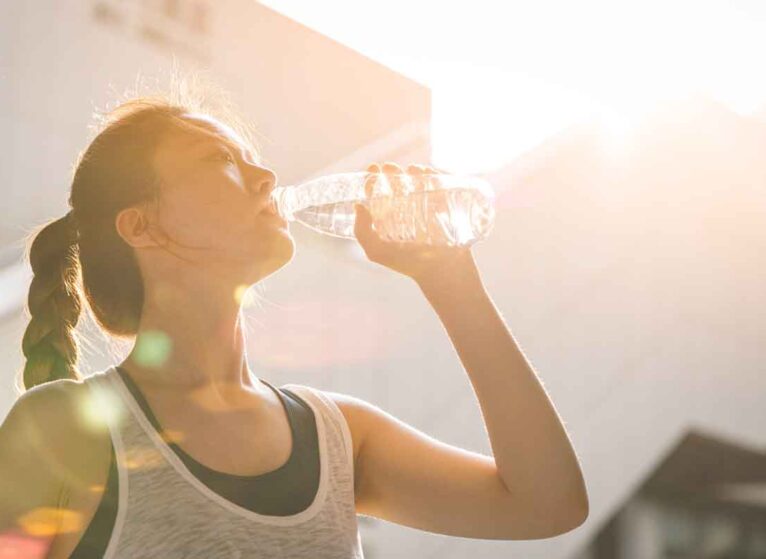 woman drinking water in hot weather