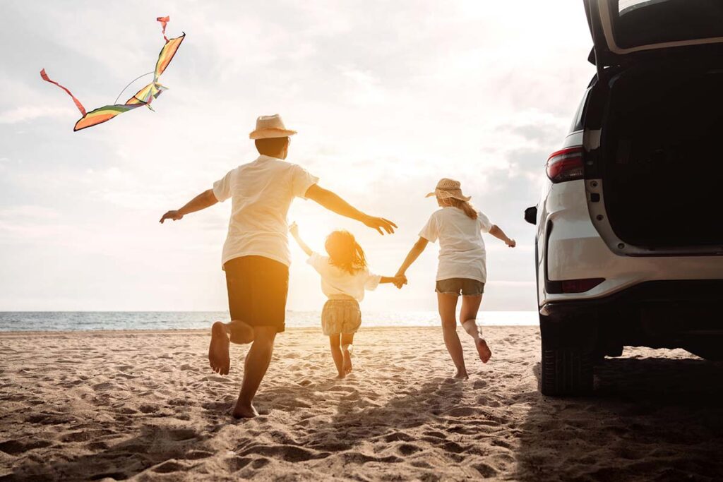 Happy family on vacation at beach with kite