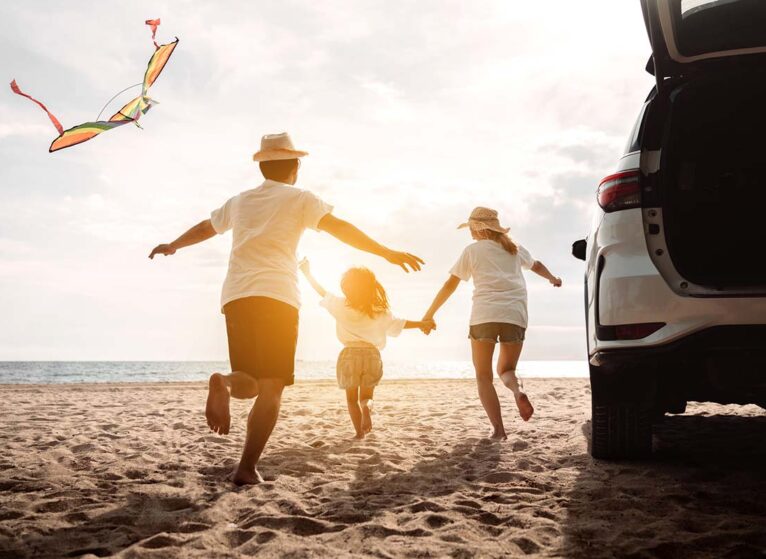 Happy family on vacation at beach with kite