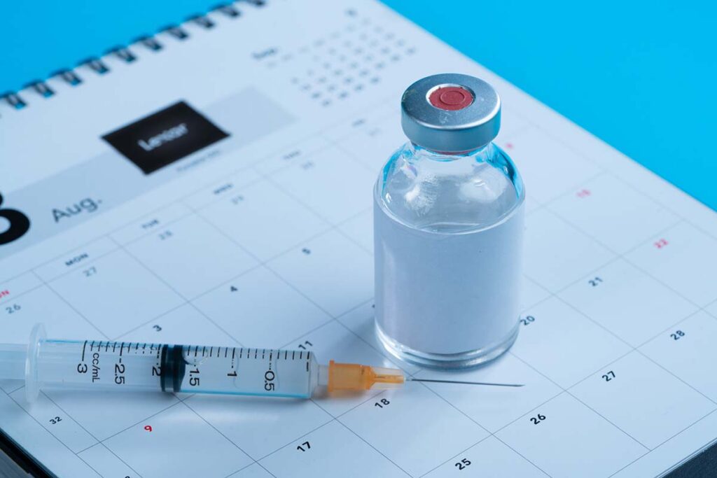 Vaccine booster rests on calendar