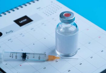 Vaccine booster rests on calendar