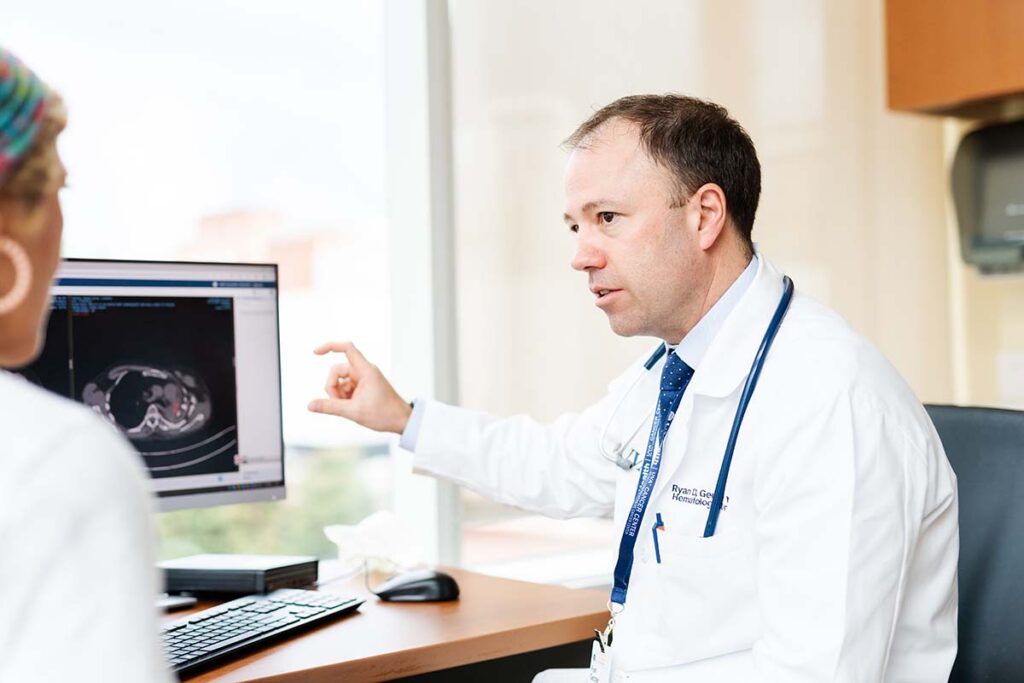 Ryan Gentzler, MD, talks with a patient